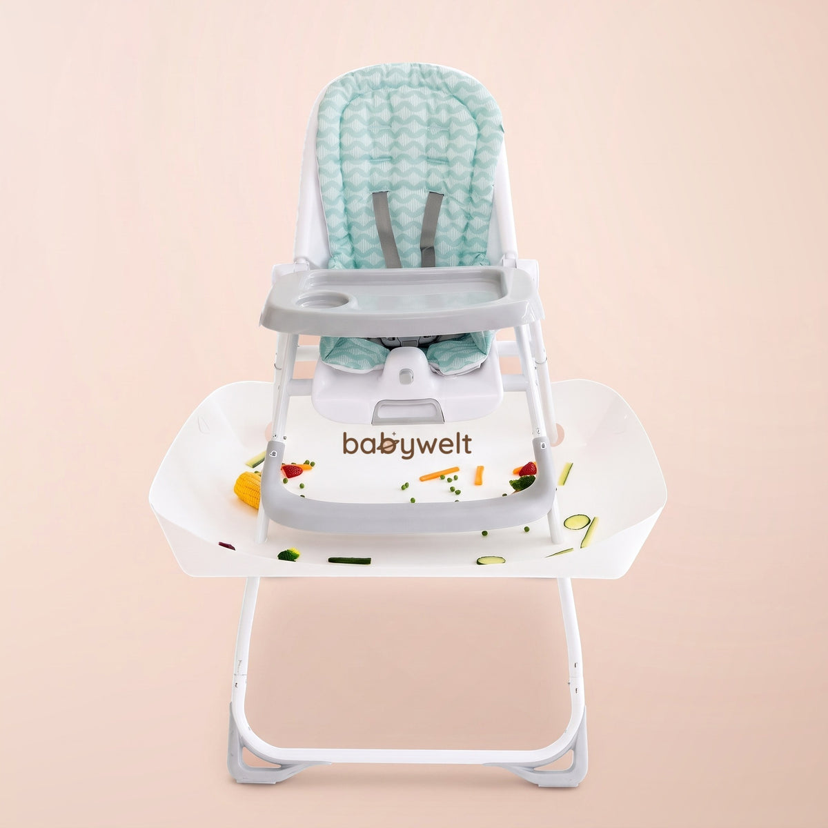 Raccogli-pappa per seggiolone bianco sotto un seggiolone pieghevole col cuscino verde