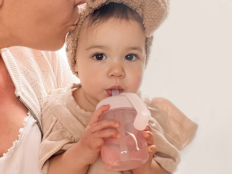 Sorsi trasparenti, Bimba che beve in braccio alla mamma